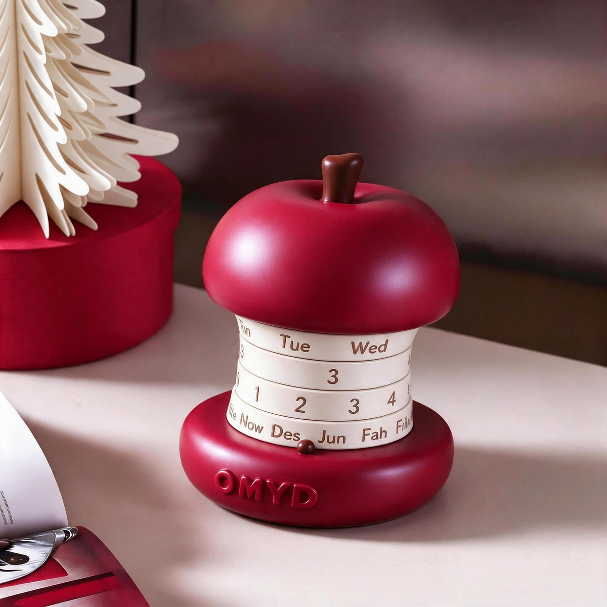 Apple core perpetual desk calendar on a desk beside a paper tree